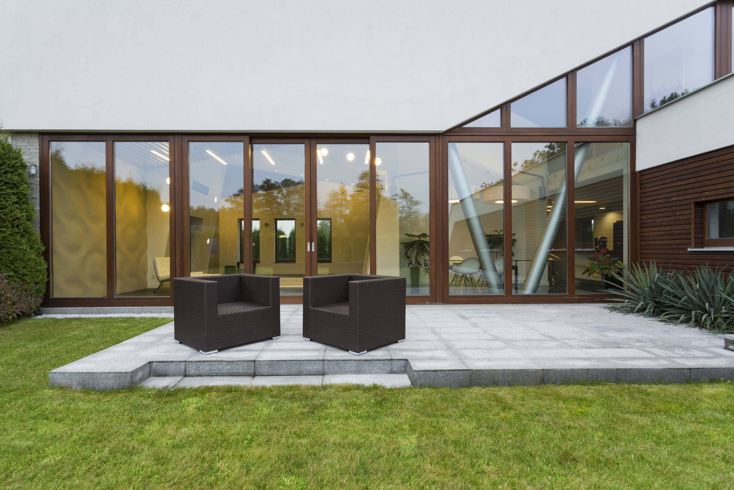 Ascetic villa patio with rattan chairs and grey floor